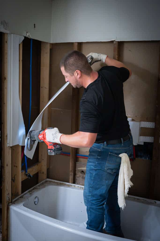 Plumber removing shower unit.