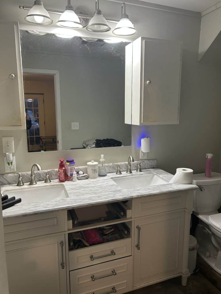 Original bathroom with bathtub, vanity, and toilet before renovation